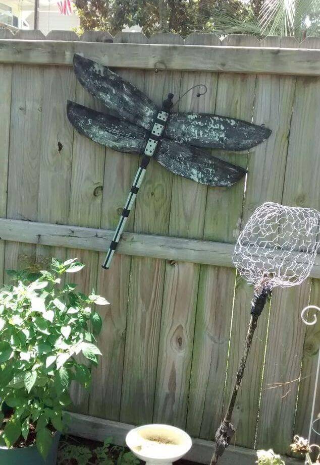Weathered Dragonfly Sign on the Fence