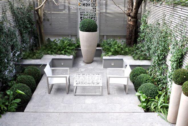 You may think you should put only small things on a small patio, but that’s not the case. Look how well this oversized urn creates a focal point on this modest-sized patio. Another clever trick here: The raised bed walls serve as extra seating.
