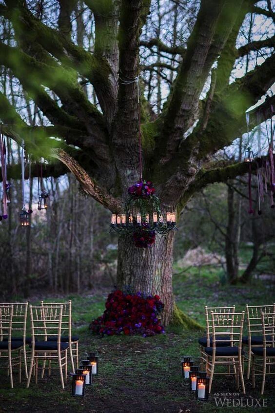 Moody florals on the tree and chandelier make the ceremony spot chic | Halloween Wedding Theme Ideas - Farmfoodfamily.com