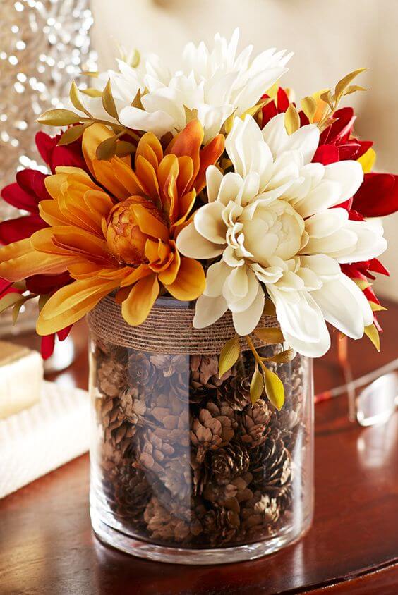A glass vase filled with pinecones | Best Thanksgiving Centerpieces