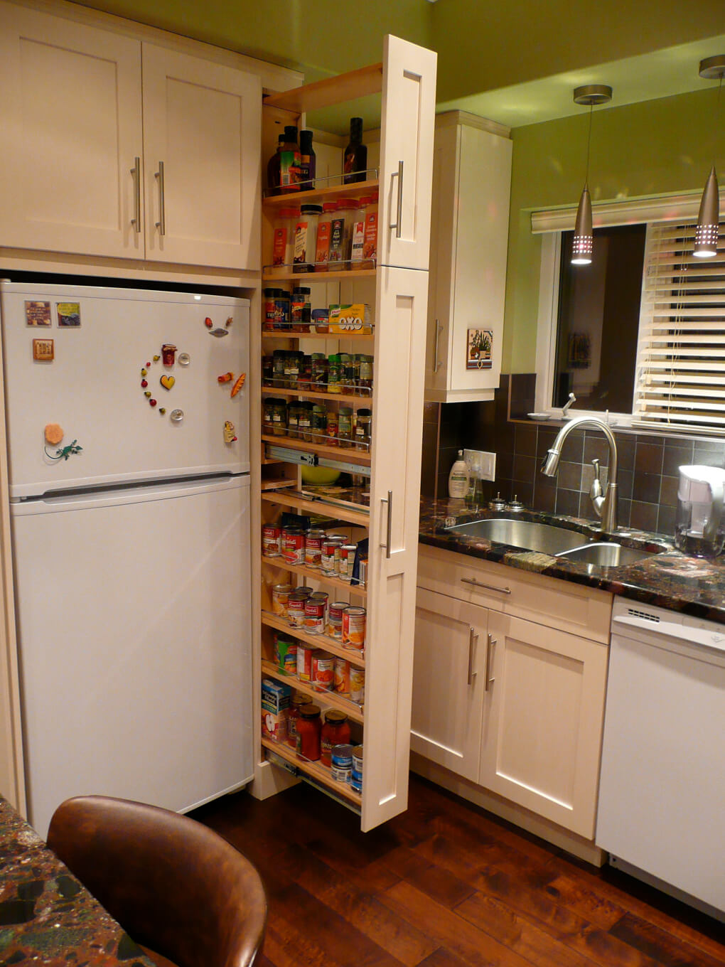 The narrow cabinet beside the fridge pulls out to reveal a spice & canned goods pantry