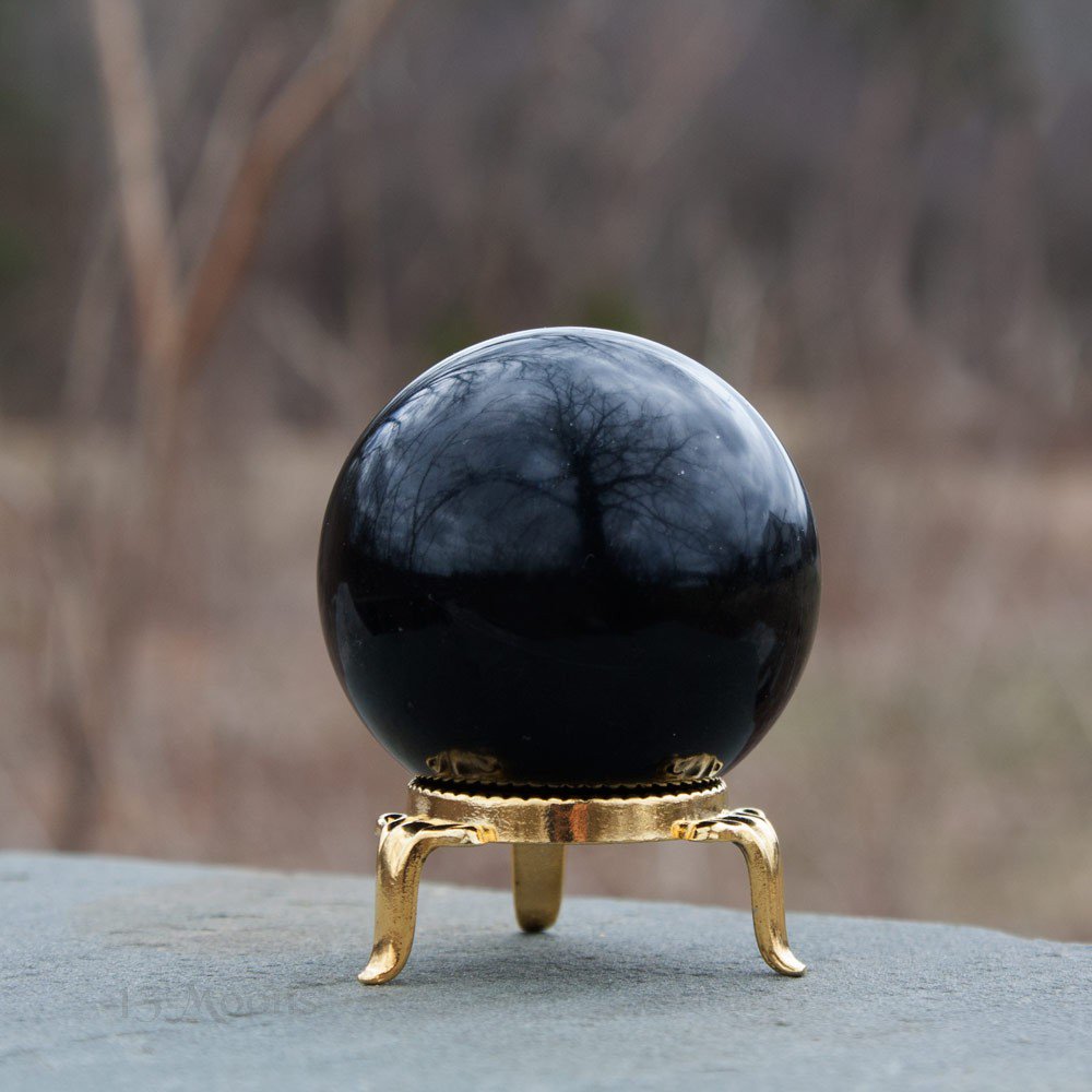 Black obsidian ball on golden support