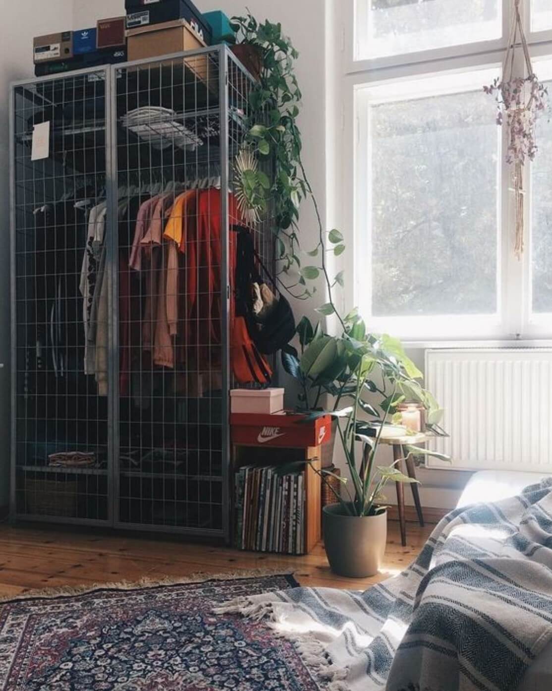 Improvised wardrobe with gray metal cage inside a room for girls