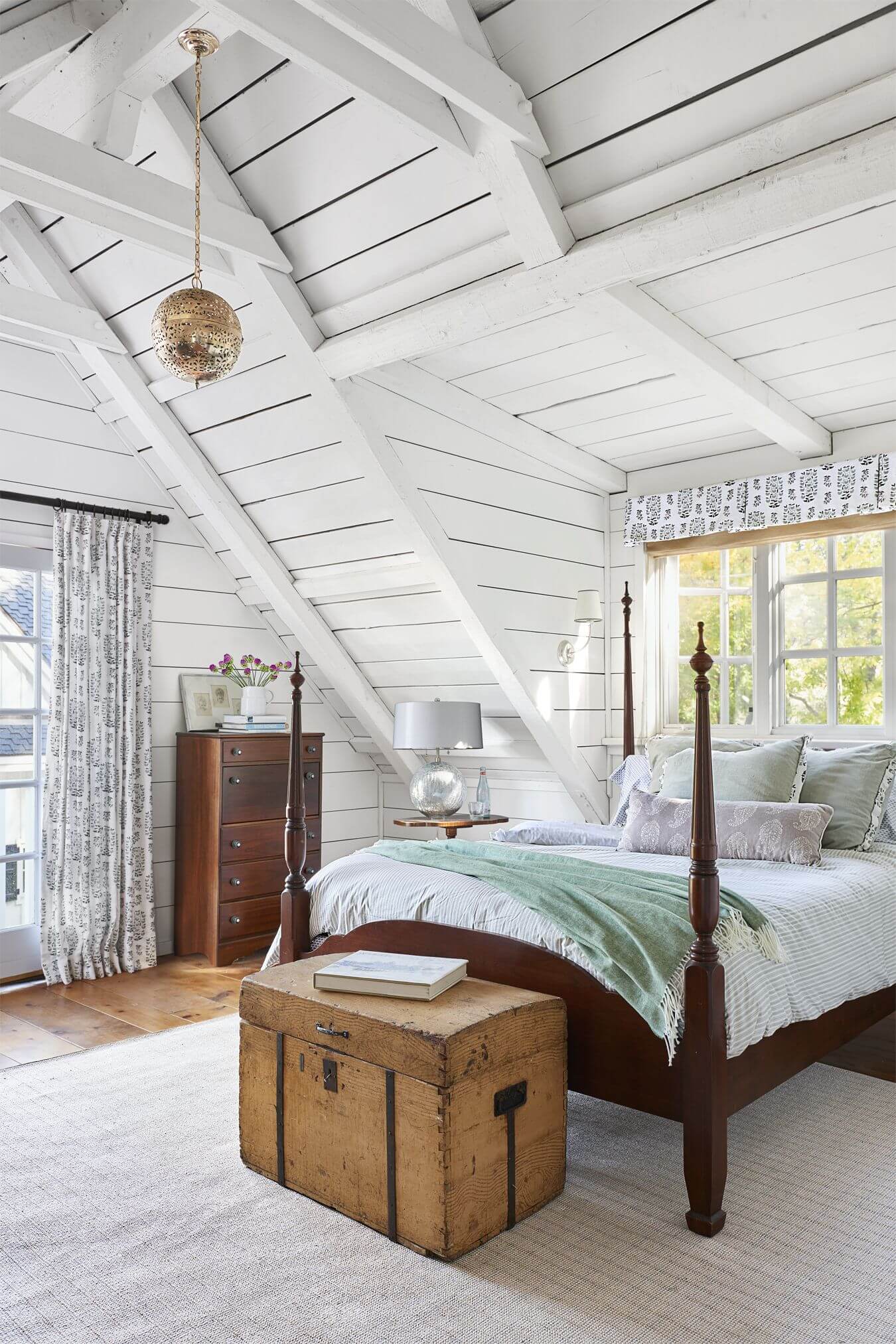 White ceilings with globe light fixture, and a vintage wood trunk