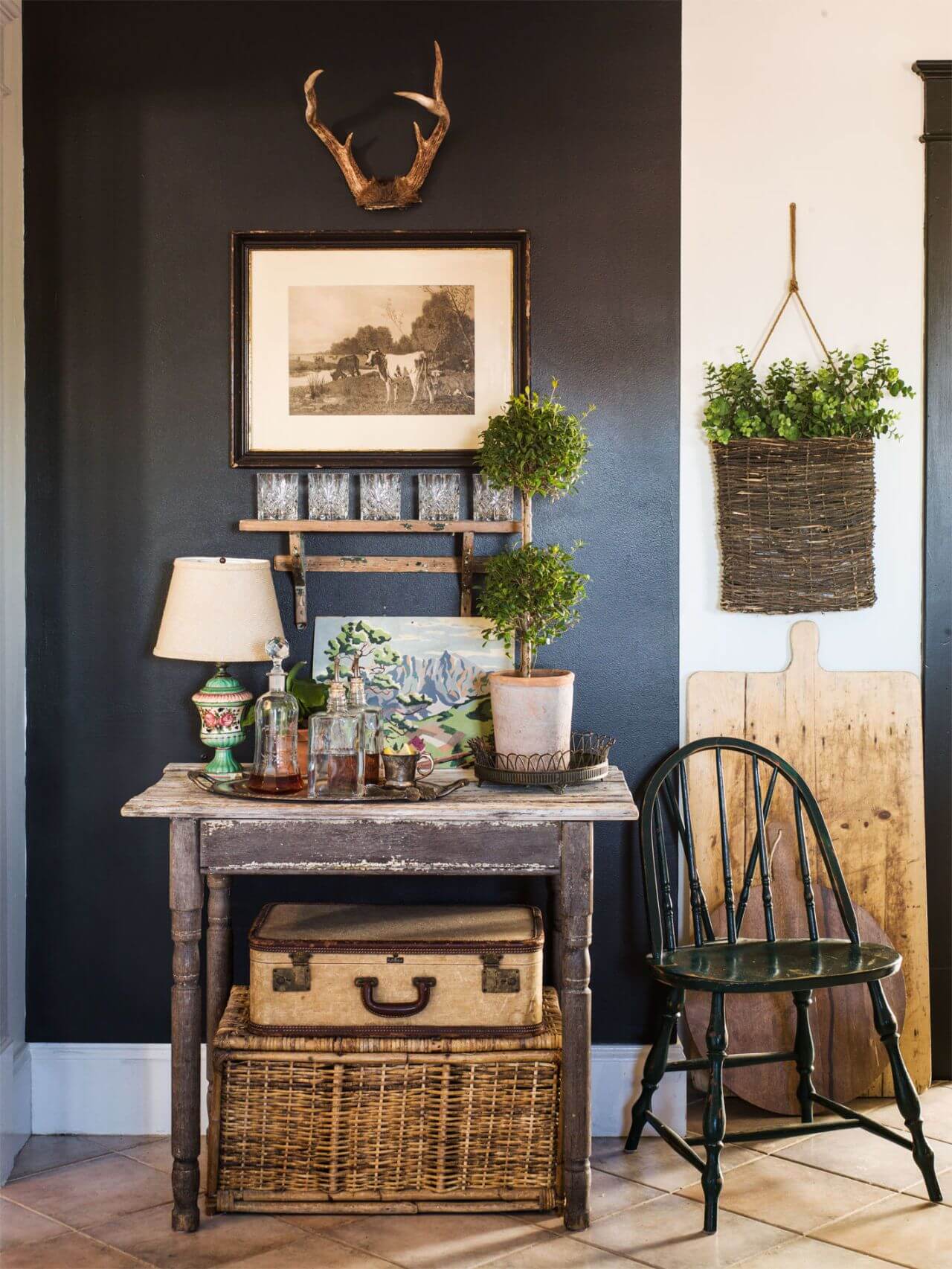 Dark accent wall, old table with topiary plants