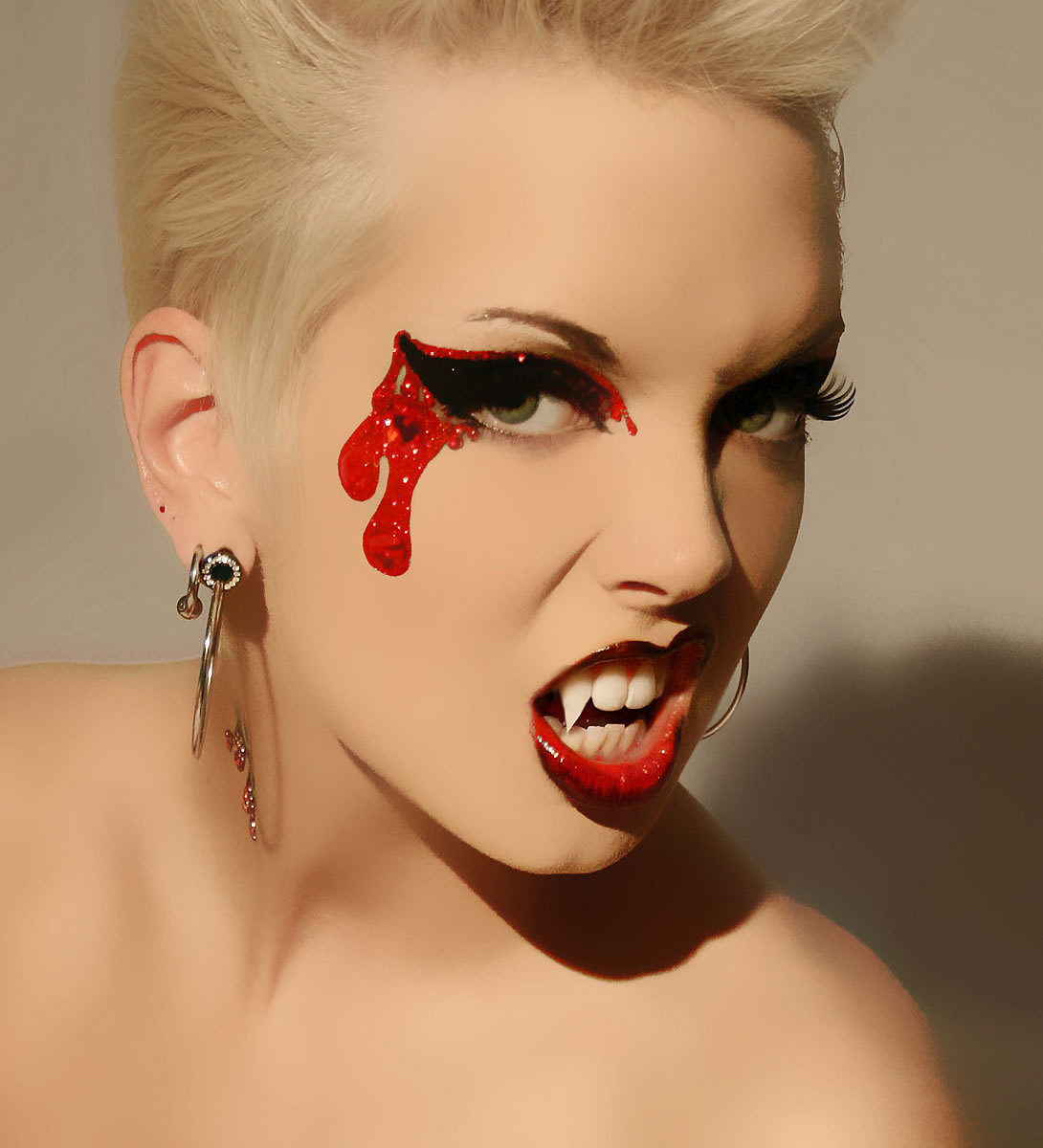 Girl with makeup for halloween vampire with fangs