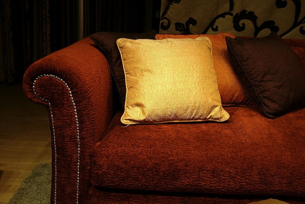 13 gold pillows with red couch