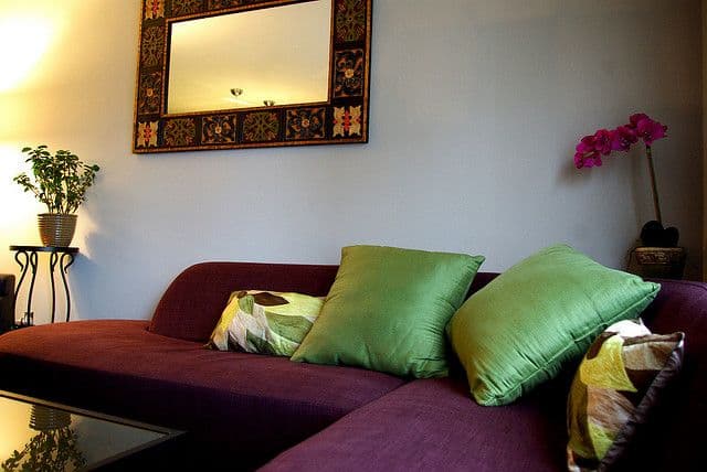 7 green pillows with red couch