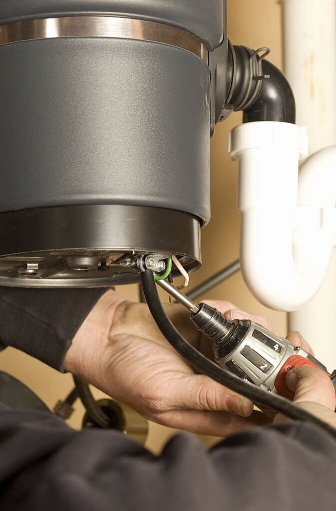 electrician wiring a new kitchen garbage disposer