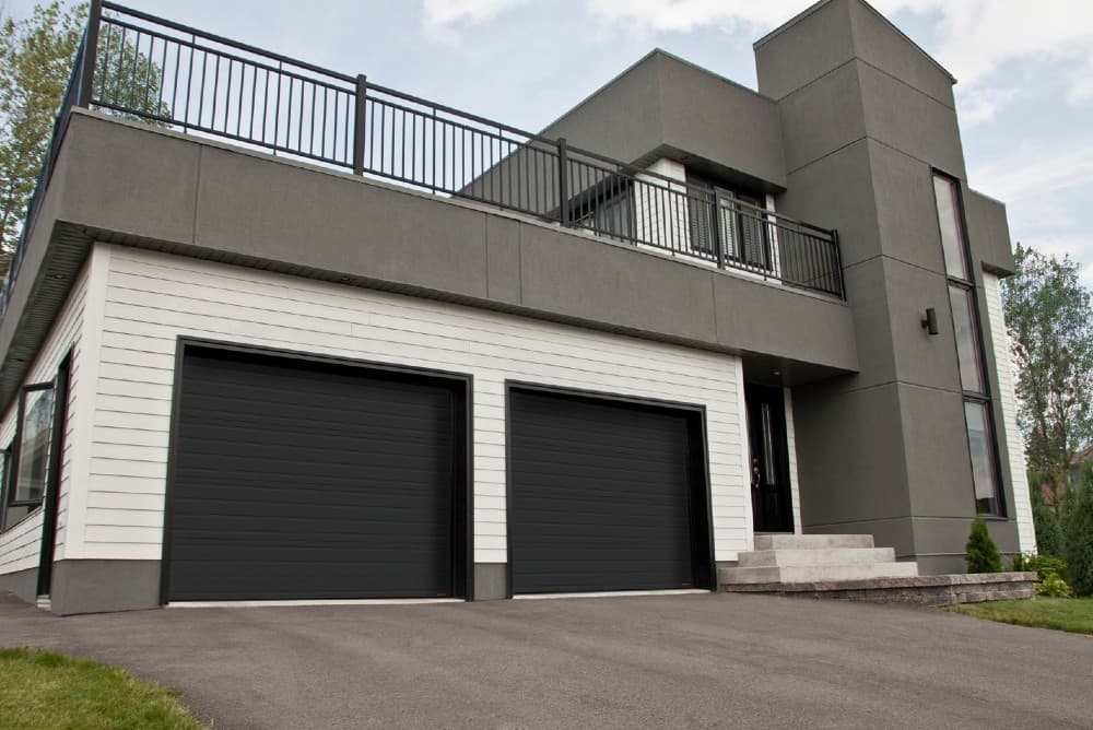 black garage door with gray house