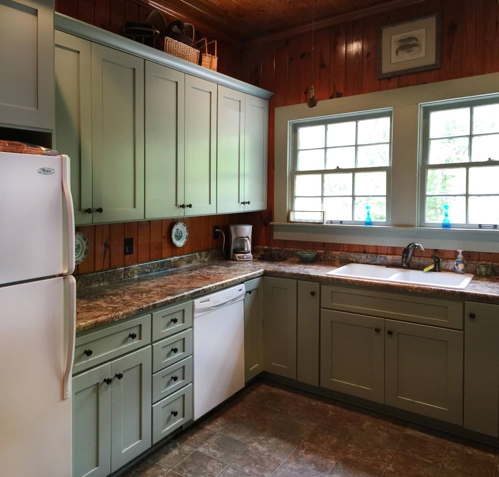 green cabinets with brown granite countertops