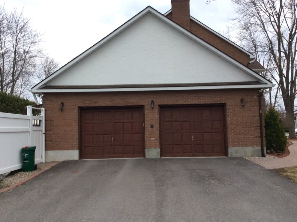 light brown garage door with red brick house