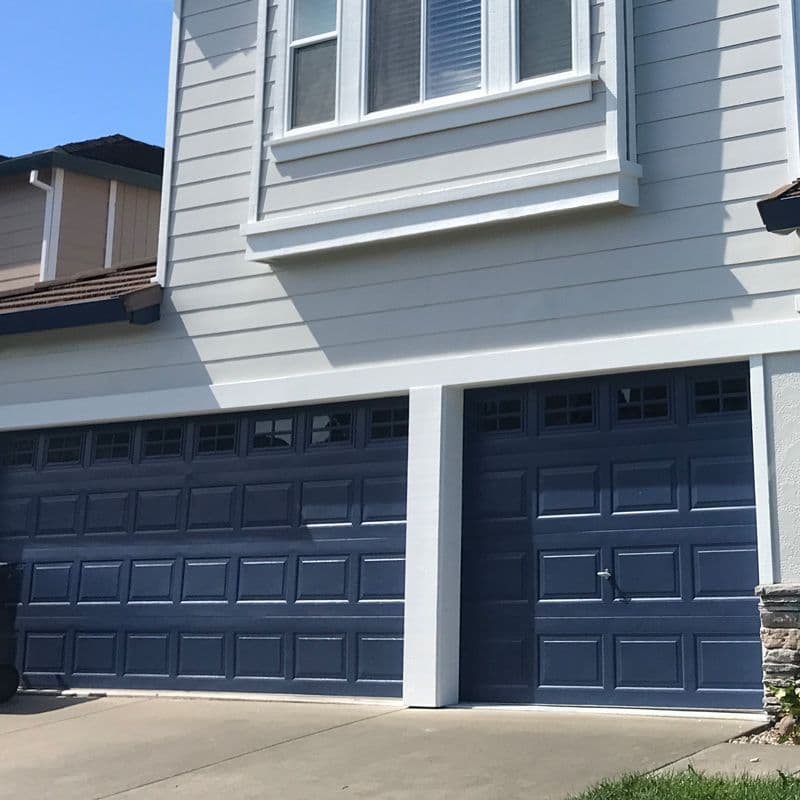 navy blue garage door with gray house