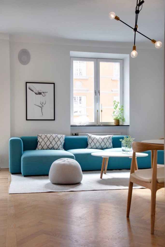 teal couch with gray walls