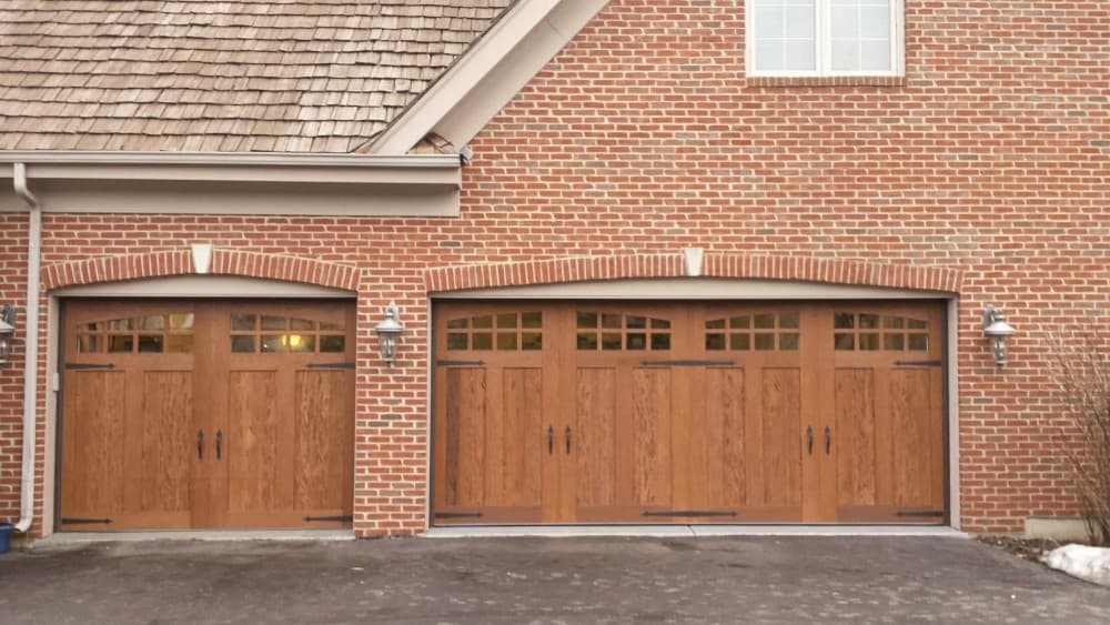 wood garage door with red brick house