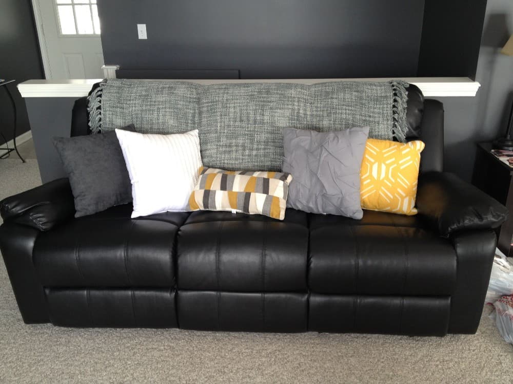 gray pillows with black leather couch